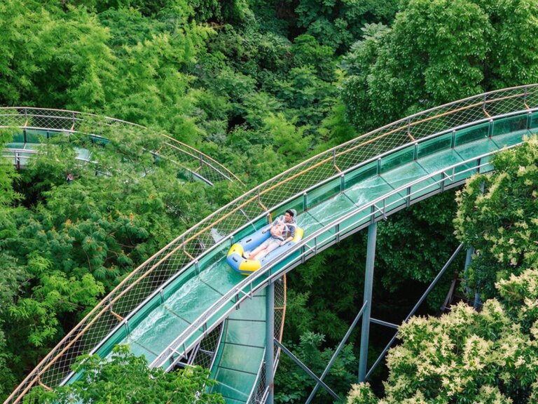 Glass water slide flume descending a hillside